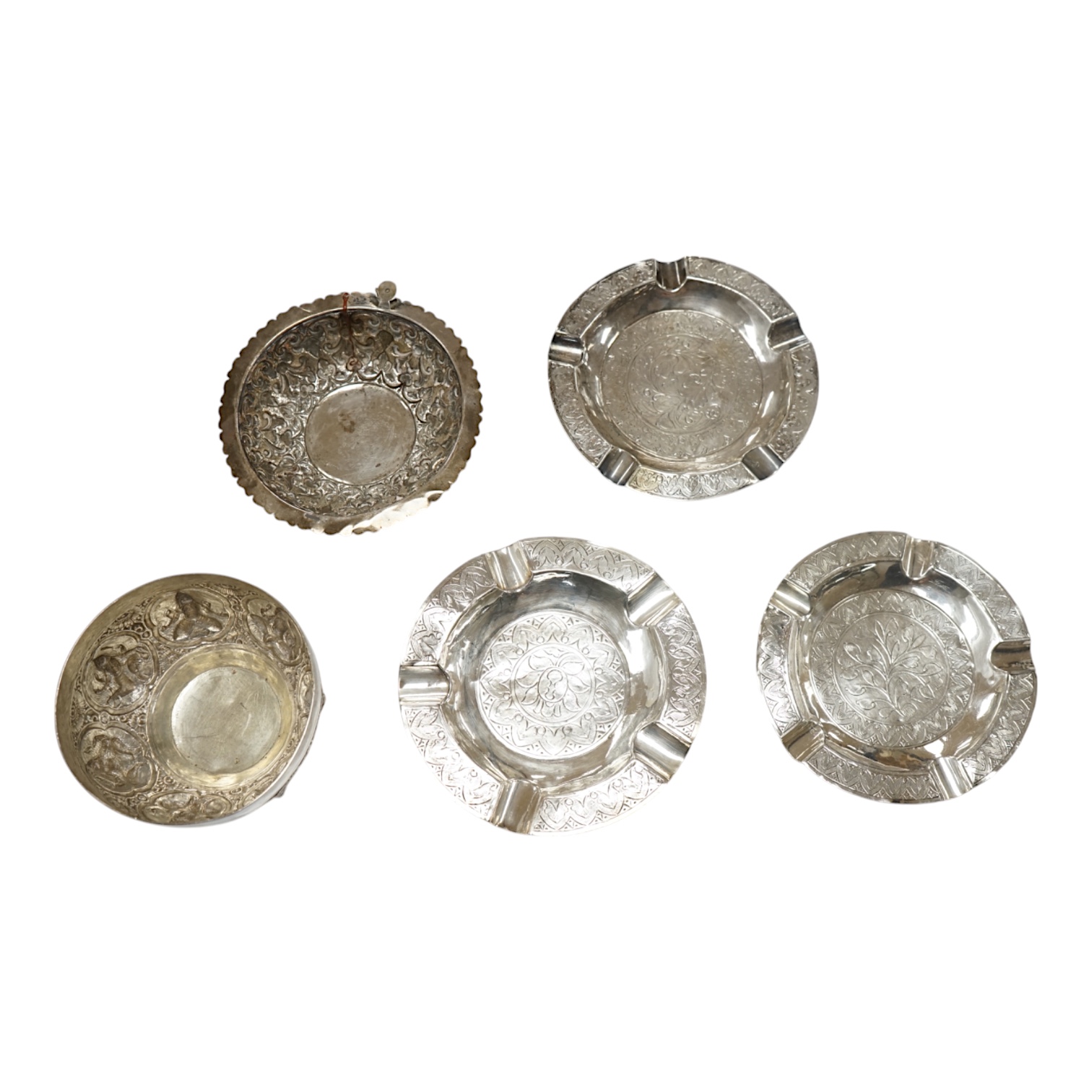 Three Malaysian or Indonesian white metal ashtrays, largest diameter 12.5cm, a similar dish and a bowl. Condition - poor to fair